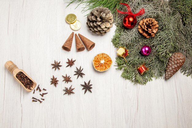 Vue de dessus de l'arbre de noël avec des cônes et des jouets sur un espace blanc