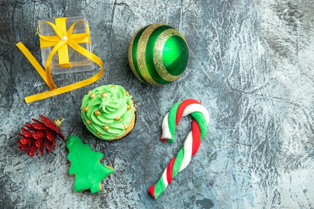 Vue de dessus arbre de Noël cupcake bonbons de Noël jouets d'arbre de Noël sur la surface grise lieu libre photo du nouvel an