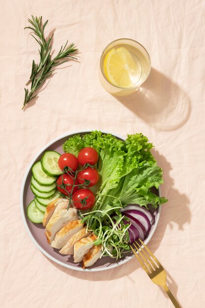 Vue de dessus de l'assiette avec des aliments diététiques céto et une branche de romarin