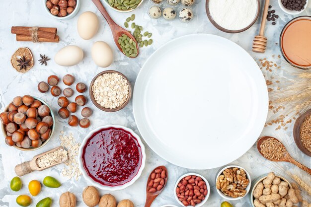 Vue de dessus assiette blanche avec oeufs en gelée différentes noix et graines sur pâte blanche biscuit couleur sucre noix douce photo