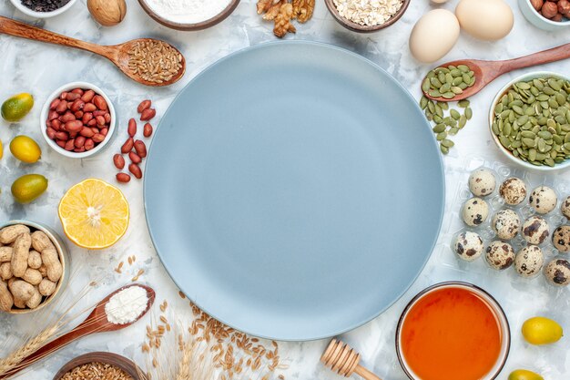 Vue de dessus assiette bleue avec des œufs de gelée de farine et différentes noix sur des noix de fruits blancs photo de sucre tarte aux couleurs de pâte sucrée