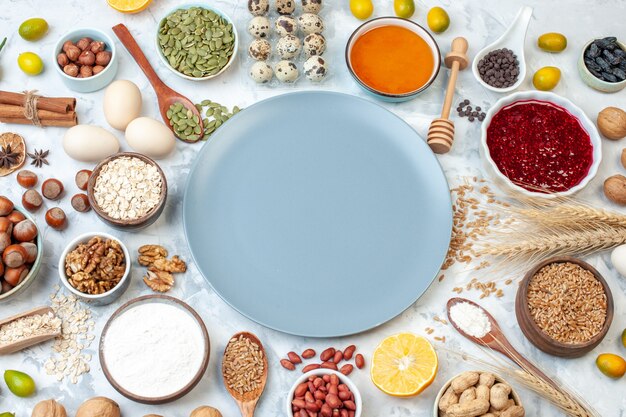 Vue de dessus assiette bleue avec des œufs de gelée de farine et différentes noix sur une pâte blanche gâteau aux fruits photo de sucre tarte aux couleurs douces