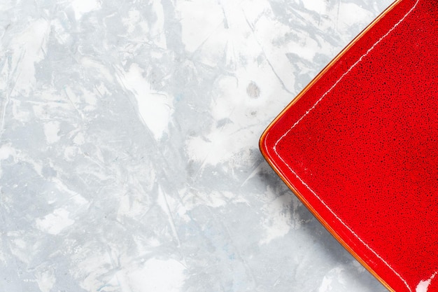 Vue de dessus assiette carrée vide ed rouge sur un bureau blanc