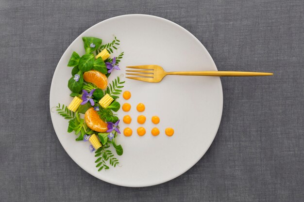 Vue de dessus assiette élégante avec fourchette dorée