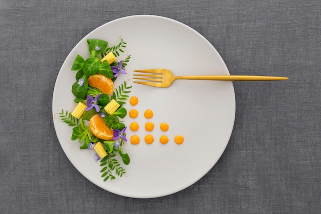 Vue de dessus assiette élégante avec fourchette dorée