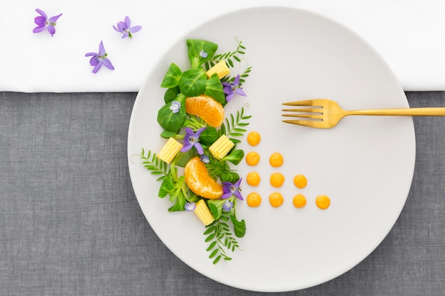 Vue de dessus assiette élégante avec fourchette dorée