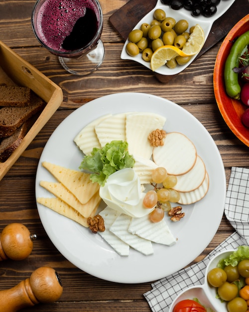 Photo gratuite vue de dessus de l'assiette de fromages au vin rouge