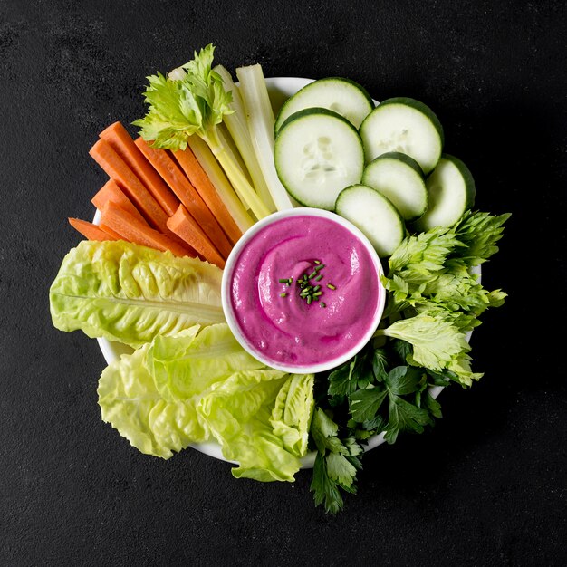 Vue de dessus de l'assiette avec légumes et sauce rose