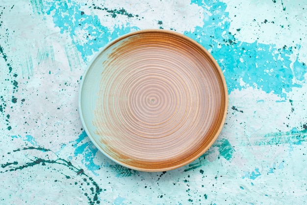 Vue de dessus de l'assiette vide marron sur bleu clair, plat alimentaire repas