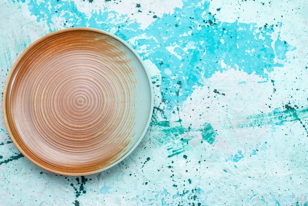 Vue de dessus de l'assiette vide marron isolé sur bleu, couverts de plaque