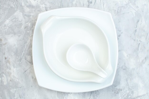 Vue de dessus des assiettes blanches sur une surface blanche, repas de cuisine en verre, couleur des aliments horizontale