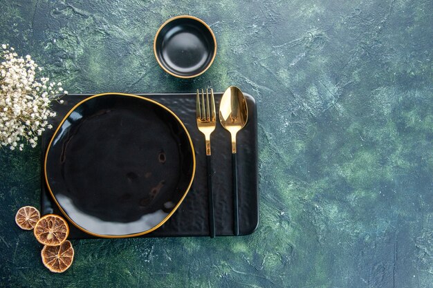 Vue de dessus assiettes noires avec couverts dorés sur fond sombre couleur repas dîner argent service de restauration couverts nourriture