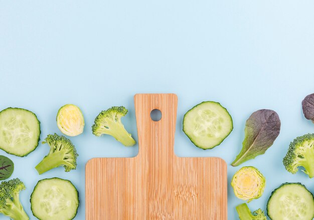 Vue de dessus assortiment de tranches de concombre avec planche à découper