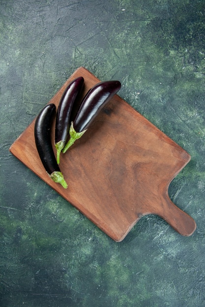 Vue de dessus aubergines noires sur fond sombre couleur salade mûre repas dîner de légumes frais