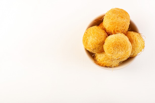 Une vue de dessus autour de délicieux gâteaux doux savoureux cuit au four formé rond à l'intérieur de la plaque blanche isolé sur fond blanc confiserie de sucre sucré