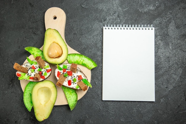 Vue de dessus des avocats crémeux avec du pain et du poivre et des avocats frais sur la surface grise