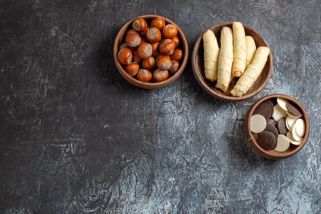 Vue de dessus des bagels sucrés avec des biscuits et des noix sur la surface sombre