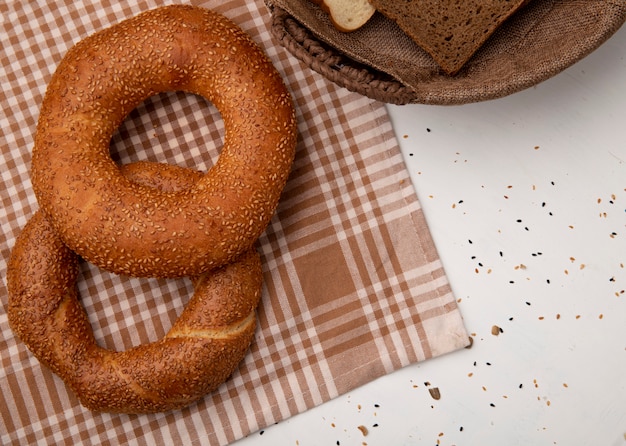 Vue de dessus des bagels sur la surface de tissu à carreaux et fond blanc avec copie espace