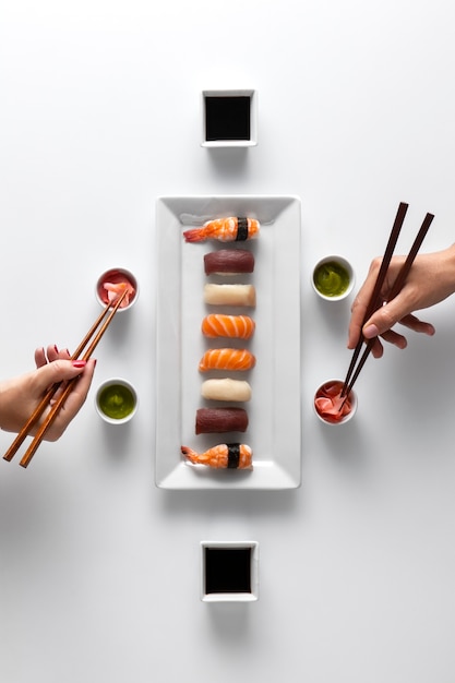 Photo gratuite vue de dessus sur les baguettes avec des sushis