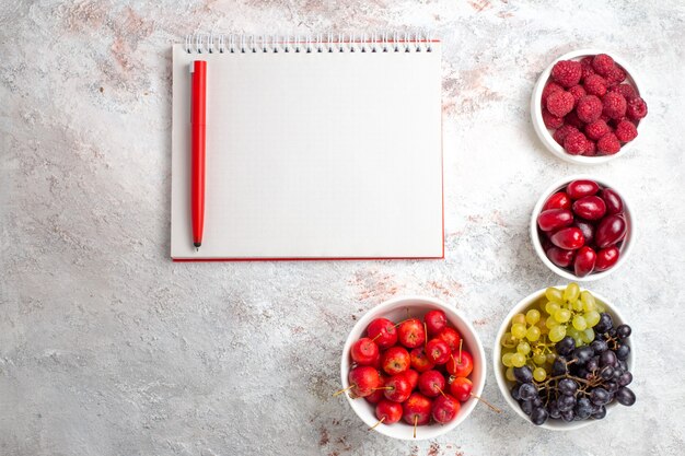 Vue de dessus les baies de fruits frais et les raisins sur une surface blanche fruit berry plante arbre fraîcheur douce