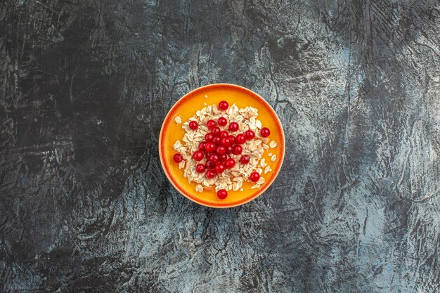 Vue de dessus des baies les groseilles rouges appétissantes sur la plaque orange sur la table grise