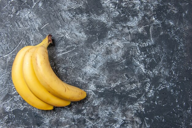 Vue de dessus des bananes fraîches sur fond gris espace libre