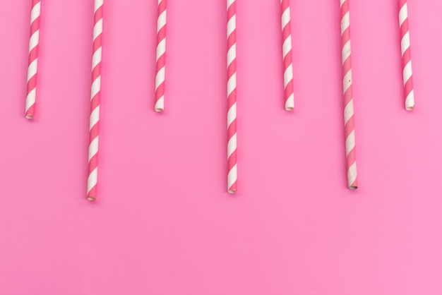 Une vue de dessus bâtonnets de bonbons rose-blanc délicieux collant sur rose, couleur de bonbons de sucre candy