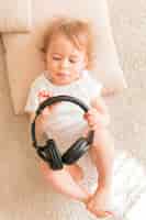 Photo gratuite vue de dessus bébé tenant des écouteurs