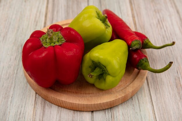 Vue de dessus de bell et de piments sains sur une planche de cuisine en bois sur un mur en bois gris