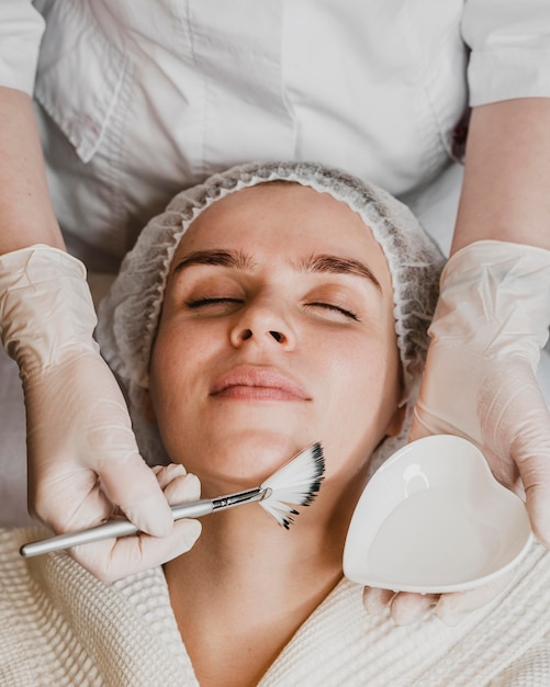 Vue de dessus de la belle jeune femme obtenant un traitement de la peau du visage