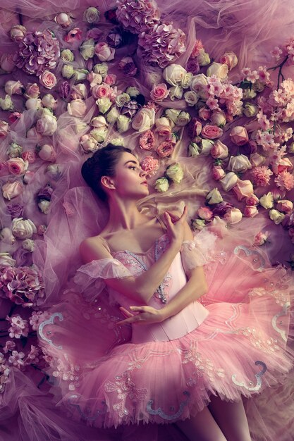 Vue de dessus de la belle jeune femme en tutu de ballet rose entouré de fleurs