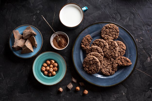 Vue de dessus des biscuits au chocolat sur une plaque avec du lait et des noisettes