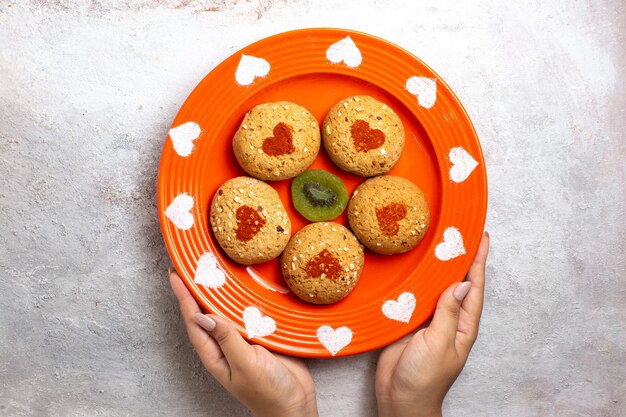 Vue de dessus des biscuits au sucre rond à l'intérieur de la plaque sur une surface blanche biscuit biscuit pâte à thé gâteau sucré