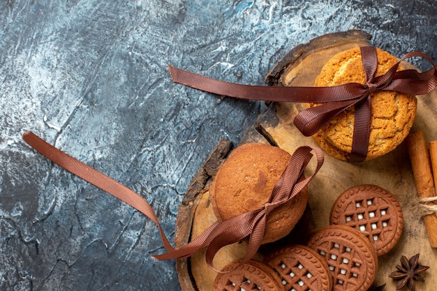 Photo gratuite vue de dessus des biscuits et des biscuits anis bâtons de cannelle sur planche de bois sur place de copie de table sombre