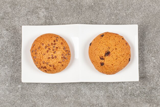 Vue de dessus des biscuits faits maison sur plaque blanche.