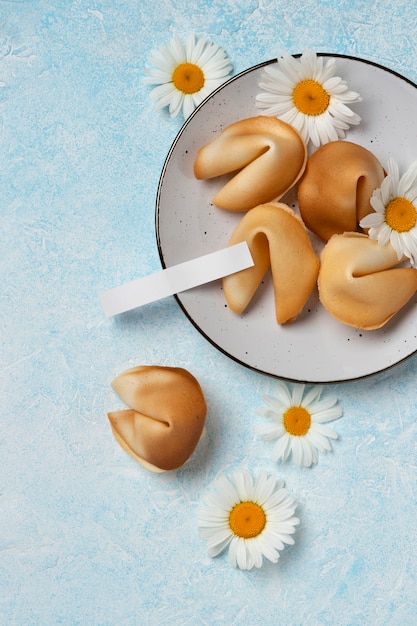 Photo gratuite vue de dessus des biscuits de fortune et des fleurs