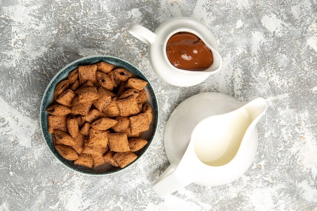 Vue de dessus des biscuits d'oreiller sucrés avec sauce au chocolat sur blanc