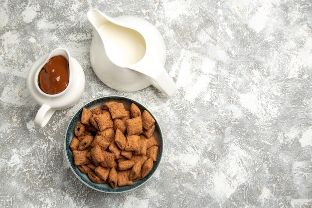 Vue de dessus des biscuits d'oreiller sucrés avec sauce choco sur blanc