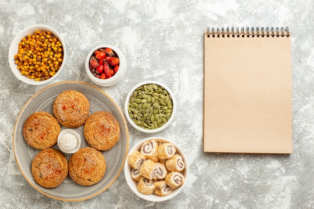 Vue de dessus biscuits de sable doux avec des fruits et des graines sur fond blanc