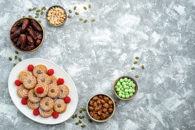 Vue de dessus des biscuits sucrés avec des bonbons et des confitures sur fond blanc biscuit sucre biscuit gâteau thé sucré