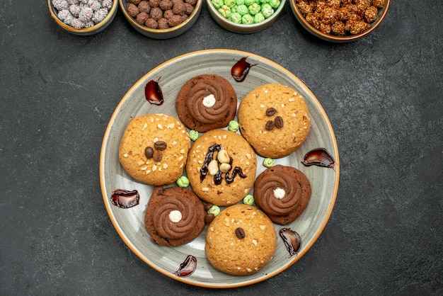 Vue de dessus biscuits sucrés avec des bonbons sur fond gris biscuit au sucre biscuit sucré gâteau thé