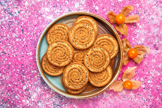 Vue de dessus des biscuits sucrés à l'intérieur de la plaque sur la surface rose