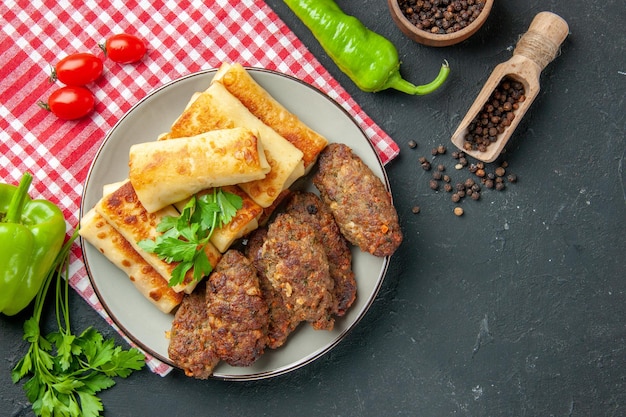 Vue de dessus blinis farcis à la viande et escalopes sur assiette ronde poivrons sur table