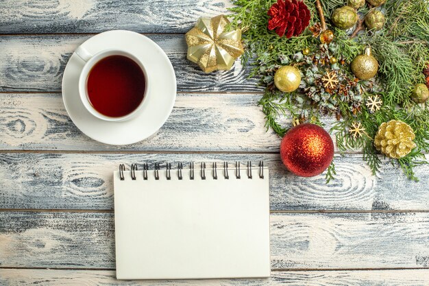 Vue de dessus un bloc-notes une tasse de branches de sapin de thé sur fond de bois