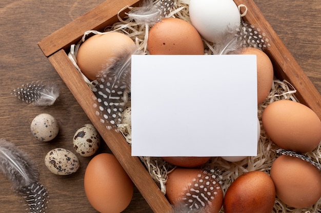 Vue de dessus de la boîte avec des oeufs pour Pâques et un morceau de papier sur le dessus