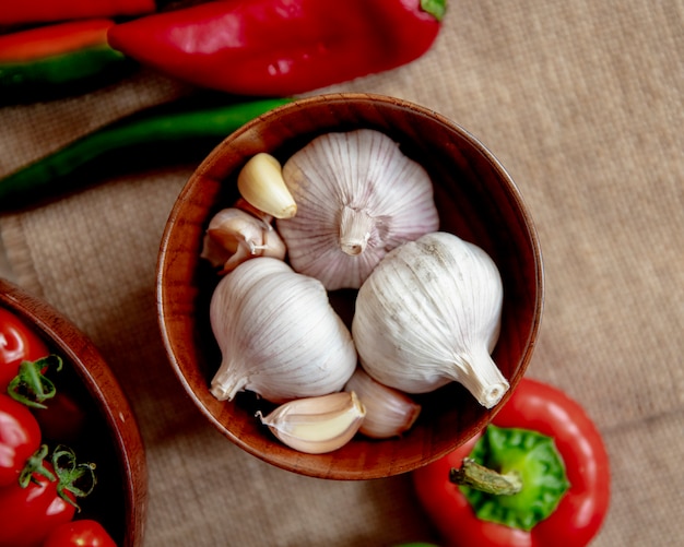 Photo gratuite vue de dessus d'un bol plein d'ail avec d'autres légumes sur la surface d'un sac