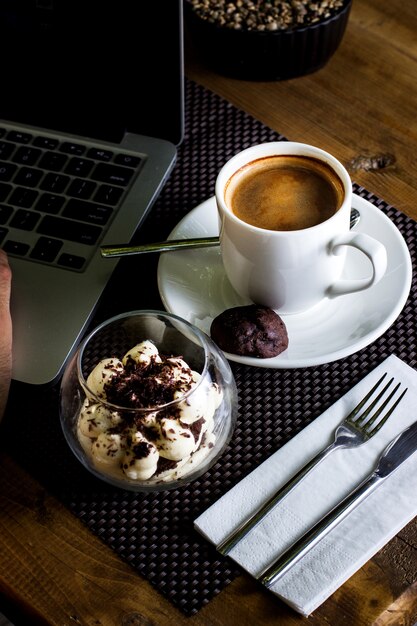 Vue de dessus d'un bol en verre de tiramisu et d'une tasse d'espresso