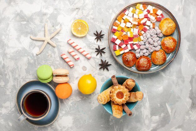 Vue de dessus des bonbons au sucre avec des petits pains sucrés et des bagels sur la surface blanche claire