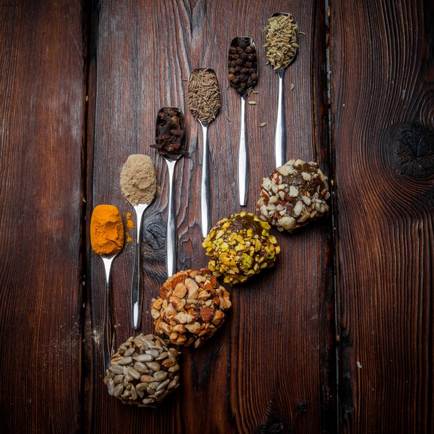 Vue de dessus des bonbons cuillères à café à la main avec des épices pour des bonbons faits à la main à partir de noix, fruits secs et miel