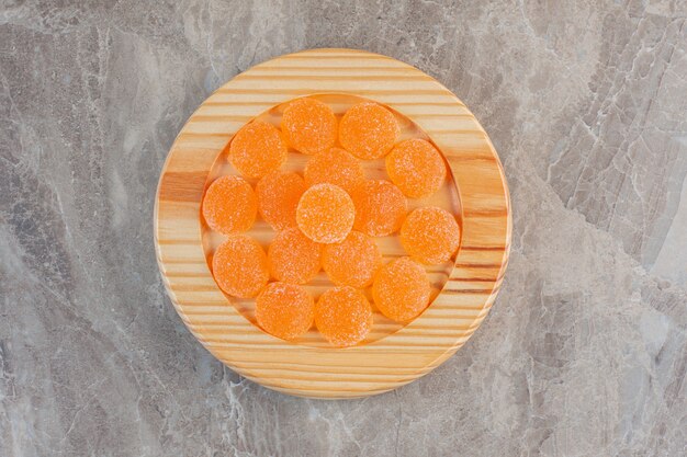 Vue de dessus des bonbons à la gelée d'orange sur planche de bois.